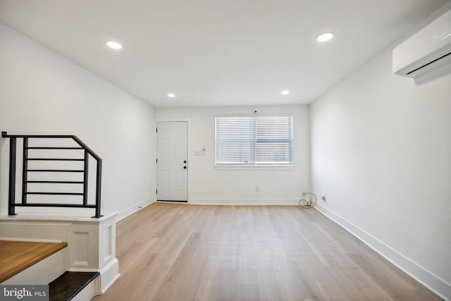 foyer with a wall unit AC and light wood-type flooring