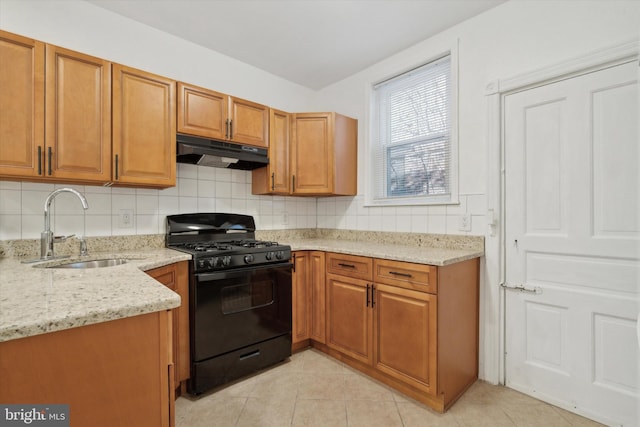 kitchen with decorative backsplash, light stone counters, sink, light tile patterned floors, and black gas range