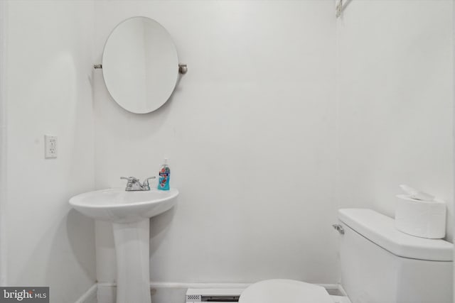 bathroom with toilet and a baseboard heating unit