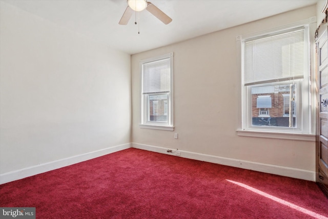 carpeted empty room with ceiling fan and plenty of natural light