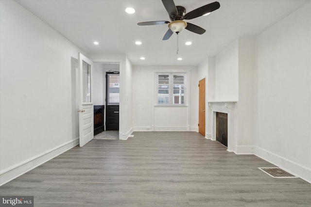 unfurnished living room with light hardwood / wood-style floors and ceiling fan