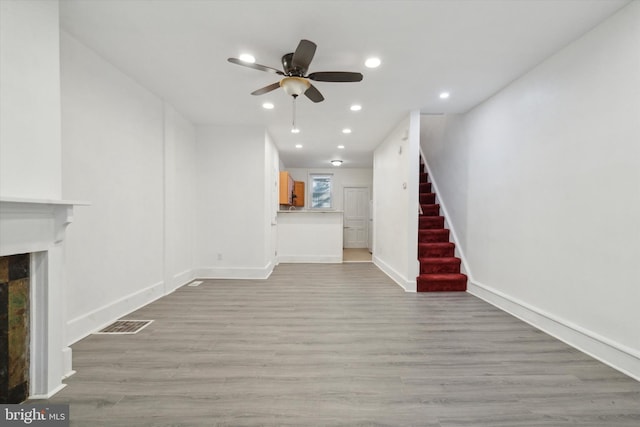 unfurnished living room featuring ceiling fan and light hardwood / wood-style flooring