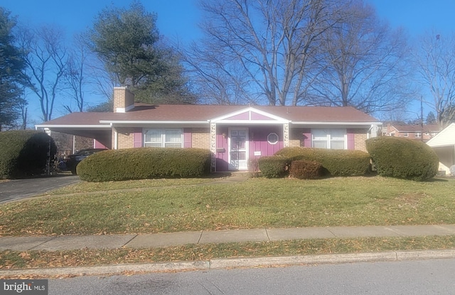 view of front of home with a carport and a front lawn