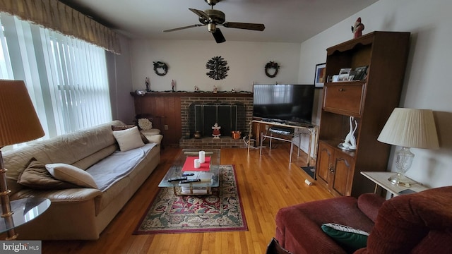 living room with a fireplace, light hardwood / wood-style floors, and ceiling fan