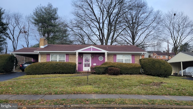 view of front of house featuring a front lawn and a carport