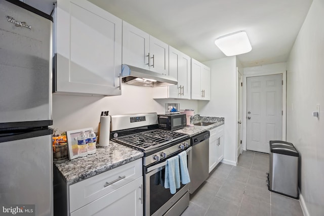 kitchen featuring sink, light tile patterned floors, appliances with stainless steel finishes, light stone counters, and white cabinetry