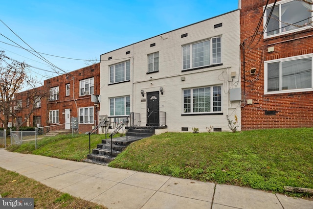 townhome / multi-family property featuring a front yard