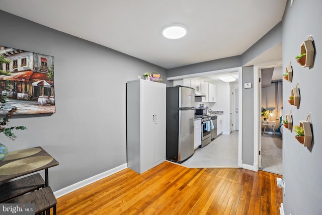 kitchen featuring light hardwood / wood-style flooring, white cabinets, and appliances with stainless steel finishes