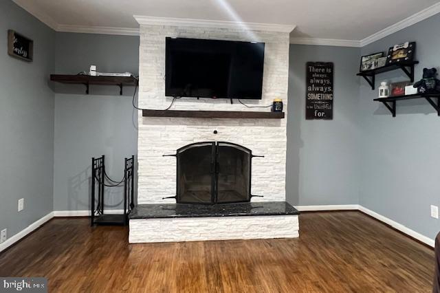 unfurnished living room featuring ornamental molding, a stone fireplace, and dark wood-type flooring