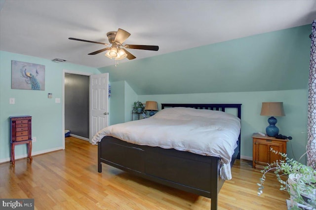 bedroom with ceiling fan, light wood-type flooring, and vaulted ceiling