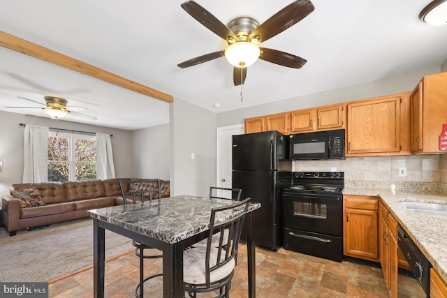 kitchen with light stone countertops, backsplash, ceiling fan, sink, and black appliances