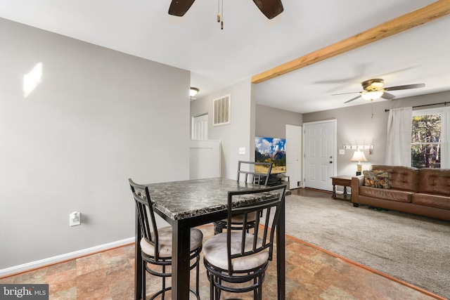 dining space featuring ceiling fan and light carpet