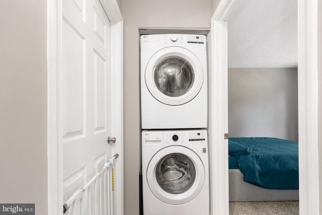 washroom with carpet and stacked washer / dryer