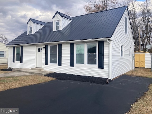 new england style home with a storage shed