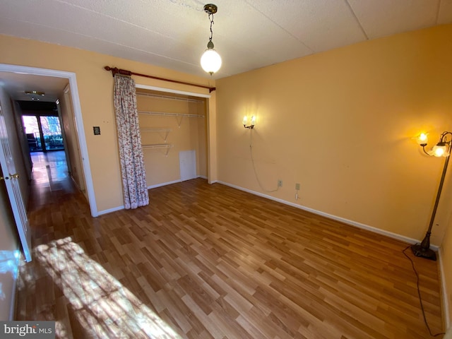 unfurnished bedroom featuring wood-type flooring and a closet