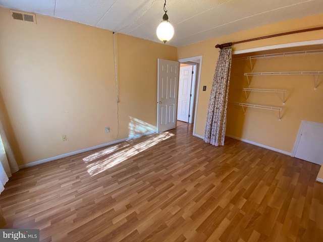 unfurnished bedroom with a closet and hardwood / wood-style flooring