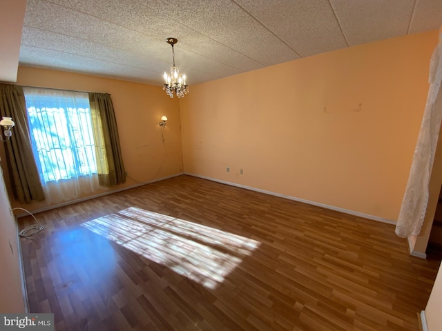 unfurnished dining area featuring an inviting chandelier and hardwood / wood-style flooring