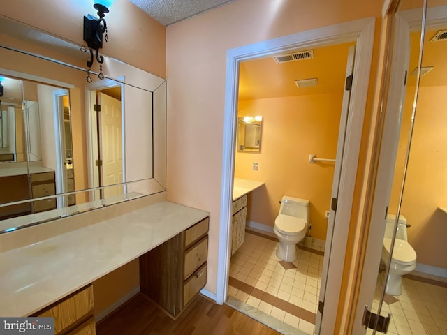 bathroom with vanity, toilet, and wood-type flooring