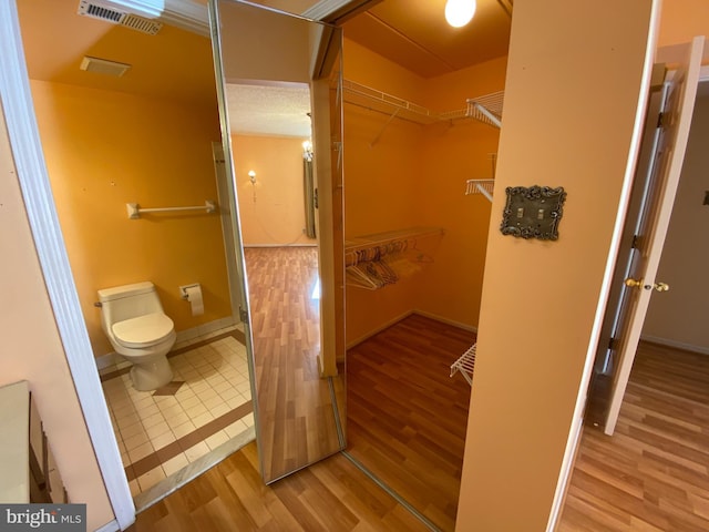 bathroom featuring wood-type flooring and toilet