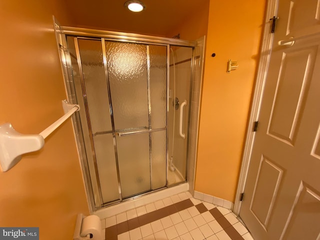 bathroom with tile patterned flooring and a shower with door