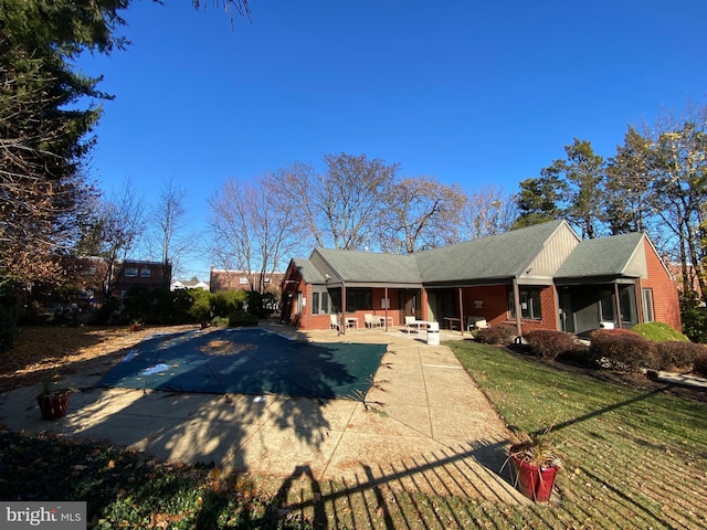 exterior space with a patio area, a yard, and a covered pool