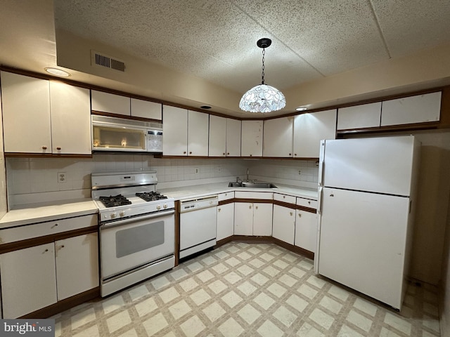 kitchen featuring pendant lighting, white cabinets, white appliances, and sink