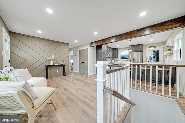 interior space with beam ceiling and light hardwood / wood-style floors