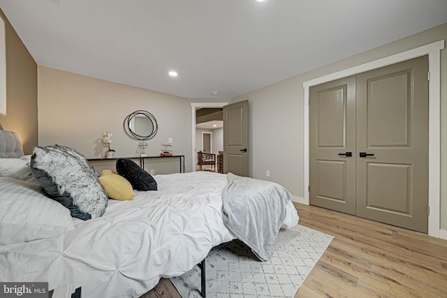 bedroom with light hardwood / wood-style floors and a closet