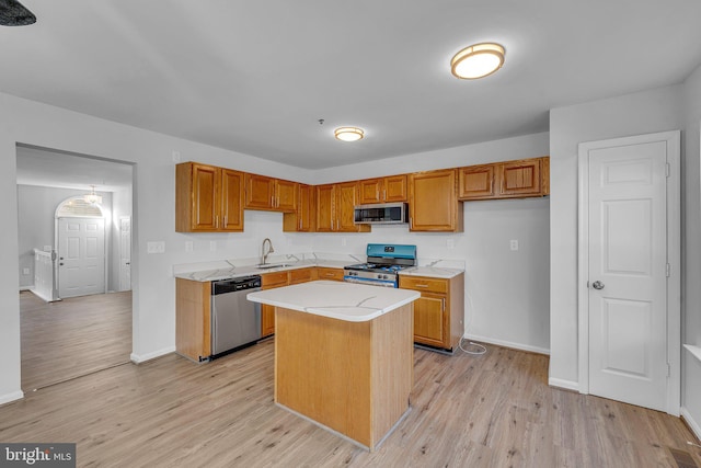 kitchen featuring light hardwood / wood-style floors, a center island, stainless steel appliances, and sink