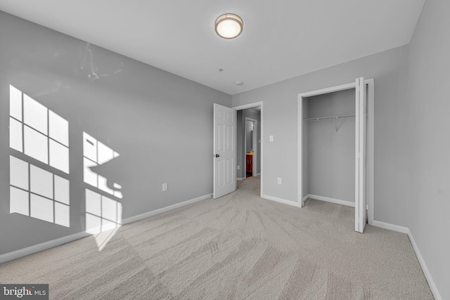 unfurnished bedroom with a closet and light colored carpet