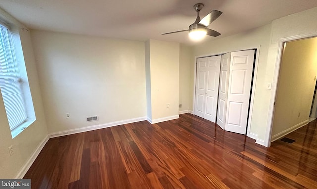 unfurnished bedroom with a closet, dark hardwood / wood-style floors, and ceiling fan