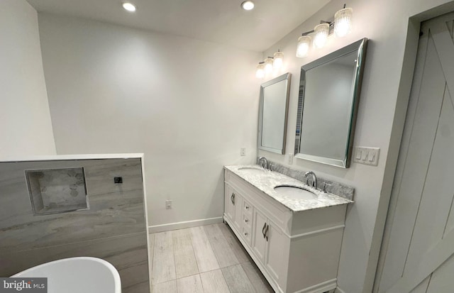 bathroom with hardwood / wood-style floors, vanity, and a tub to relax in