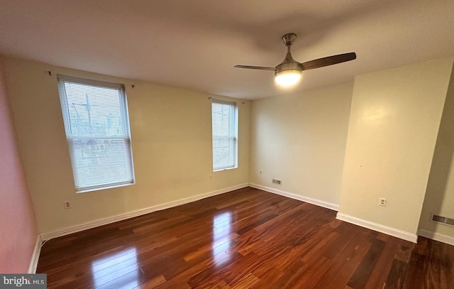 empty room with ceiling fan and dark wood-type flooring