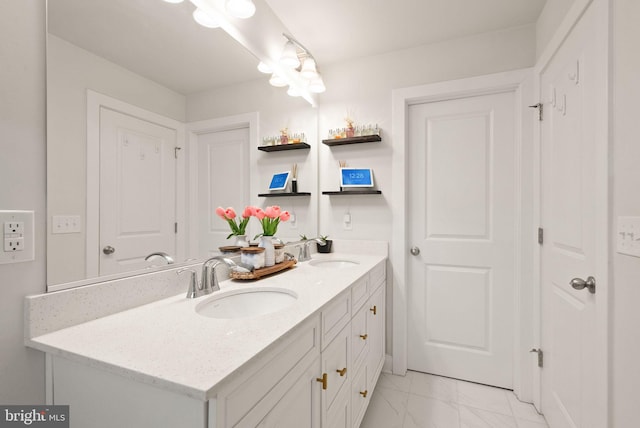 full bath with marble finish floor, a sink, and double vanity