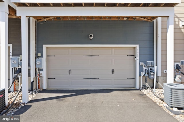 garage with driveway and central air condition unit