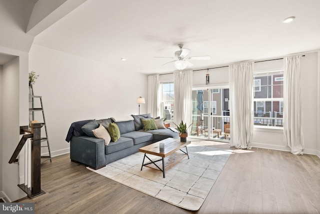 living area with ceiling fan, baseboards, and wood finished floors