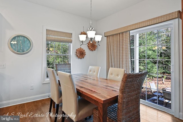 dining room with hardwood / wood-style floors and a chandelier