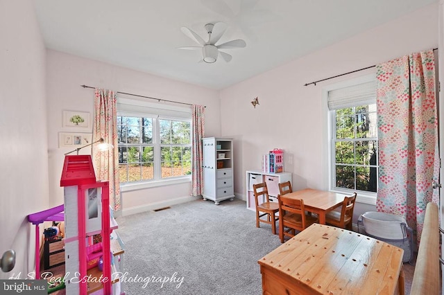 interior space with ceiling fan, plenty of natural light, and light carpet