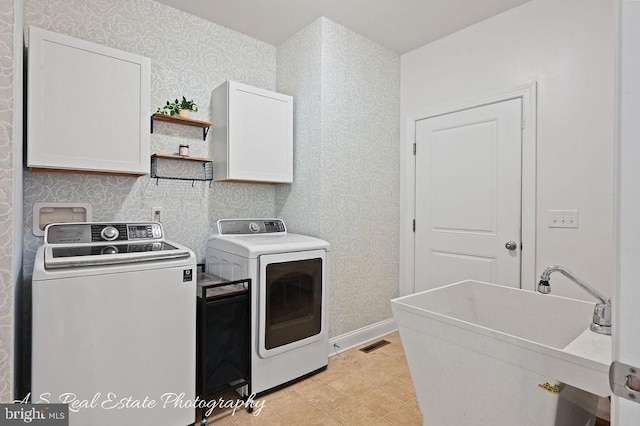 laundry room featuring washer and dryer, sink, and cabinets