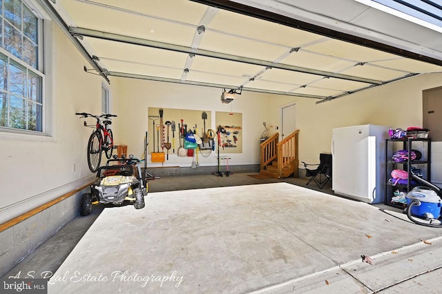 garage featuring white fridge and a garage door opener