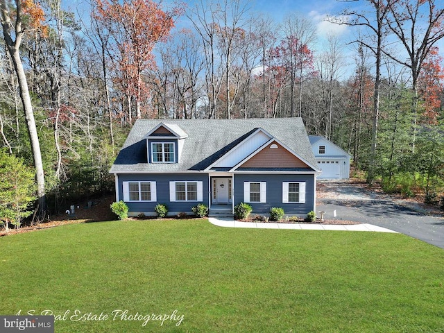 view of front of home with an outbuilding, a front lawn, and a garage