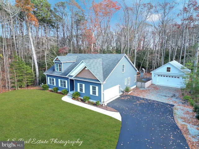 view of front of property featuring a garage, an outbuilding, and a front yard