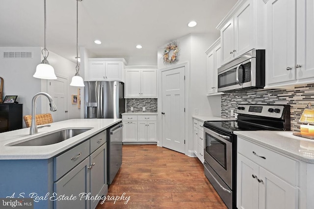 kitchen featuring appliances with stainless steel finishes, dark hardwood / wood-style flooring, and white cabinetry