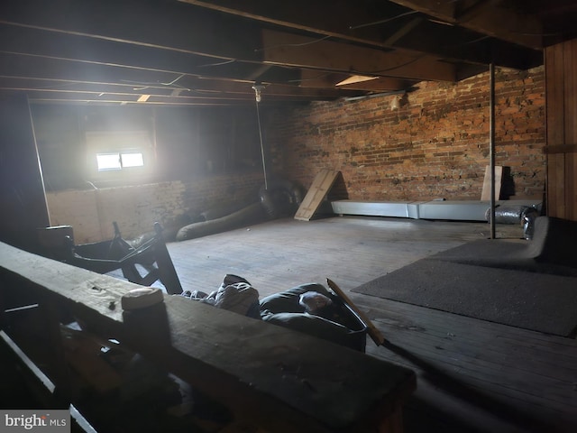 basement featuring brick wall