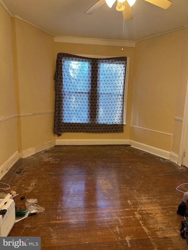 spare room with dark wood-type flooring, ceiling fan, and ornamental molding