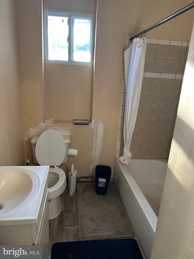 full bathroom with wood-type flooring, vanity, shower / bathtub combination with curtain, and toilet