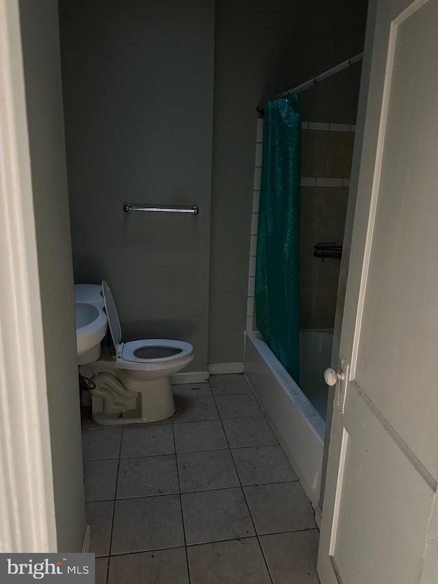 bathroom featuring tile patterned flooring, shower / tub combo, and toilet