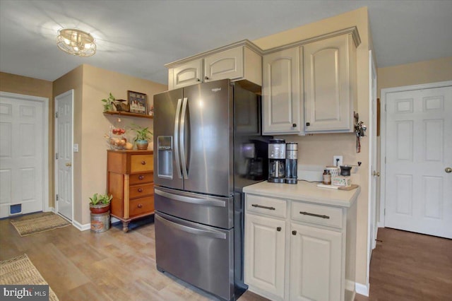 kitchen with stainless steel refrigerator with ice dispenser and light wood-type flooring