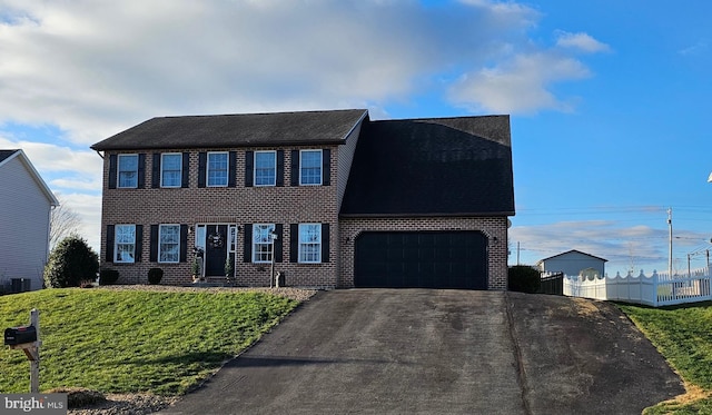 colonial home with a garage and a front lawn