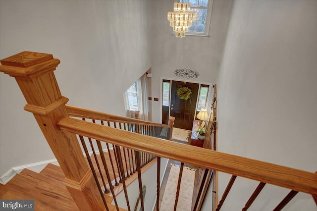 staircase with a high ceiling and a chandelier